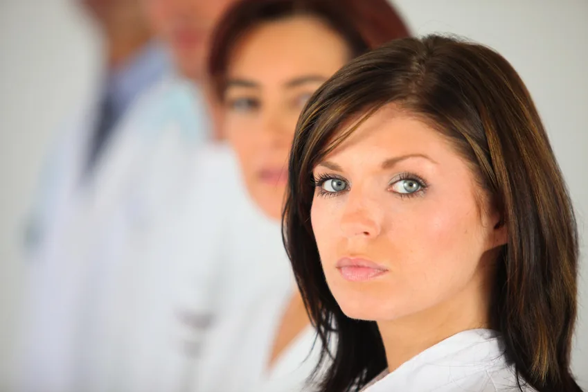 bandeau-goupe-salaries-paramedicuax Jeune femme en blouse blanche devant une équipe de soignants