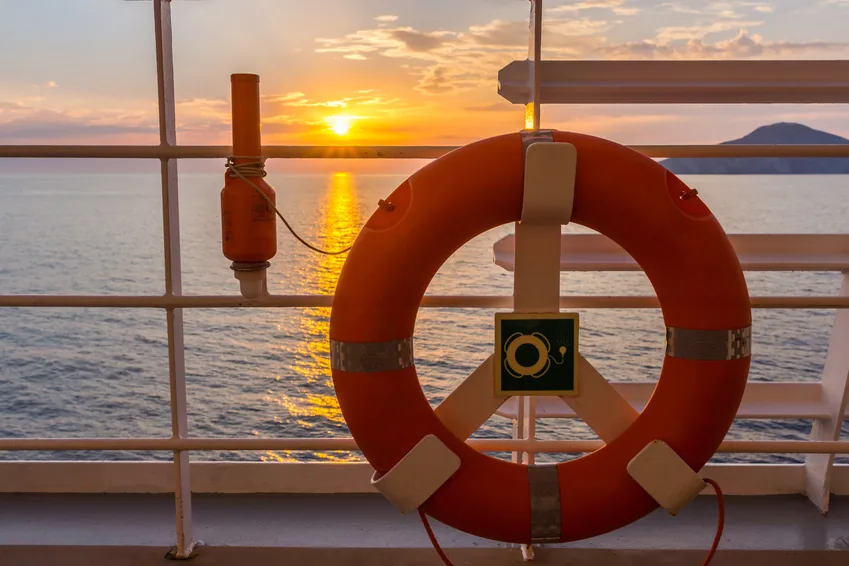 Bouée de sauvetage au bastingage d’un bateau au coucher du soleil
