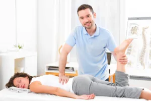 Jeune masseur-kinésithérapeute en séance avec un patient